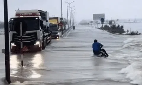 Khoảnh khắc đoàn xe tải làm 'lá chắn' giúp người đi xe máy vượt lũ gây xúc động